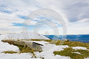 Picturesque mountain view with wooden bench for weary hikers.