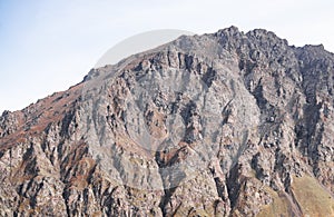 Picturesque multi-colored rocky mountain with insignificant vegetation in the mountains of the Caucasus