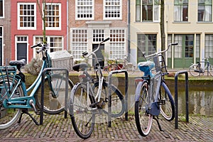 Picturesque Netherlands. Bicycles parked alongside a channel on beautiful old buildings background.