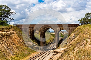Picturesque old arch bridge, viaduct with railway underneath.