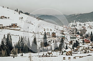 Picturesque panorama of a village in the Carpathian Mountains in Eastern Europe. Rustic winter landscape