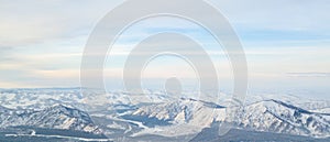 Picturesque panoramic landscape in the Altai mountains with snow-capped peaks under a blue sky with clouds in winter. White snow