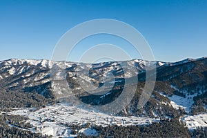 Picturesque panoramic landscape in the Altai mountains with snow-capped peaks under a blue sky with clouds in winter. White snow