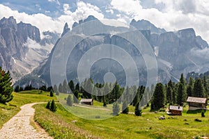 Picturesque path on a high alpine meadow surrounded by foggy peaks. Italian Dolomites.