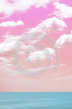 Picturesque pink and coral sky with fluffy clouds over ocean