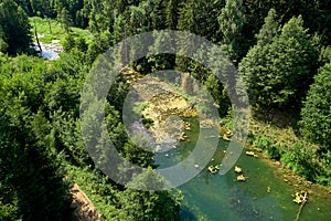 A picturesque pond surrounded by a dense forest, aerial view