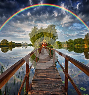 Picturesque rainbow over a wooden hut on a small island