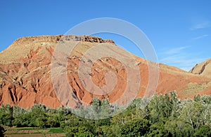 Picturesque red mountain and green froest at the bottom