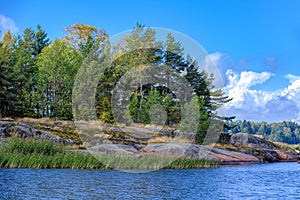 Picturesque rocky shore of the island with huge multi-ton boulders erratic blocks. Baltic fundamental crystalline formations and