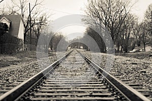 Picturesque rural village with a vintage railroad track running through the center, greyscale