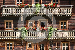 Picturesque rustic wooden house decorated with flowers in Austria