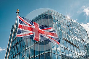 The picturesque scene captures the UK flag gracefully waving in front of a contemporary glass skyscraper against