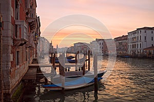 Picturesque scene of gondolas on canal in Venice, Italy, surrounded by urban buildings at sunset