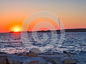 Picturesque seascape with sailing boat at sunset