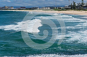 Picturesque seascape with sandy beach and unidentifiable incidental people