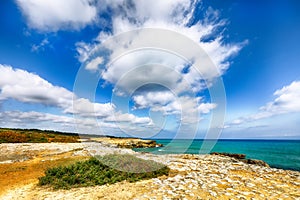 Picturesque seascape with white rocky cliffs, sea bay, islets and faraglioni near by Conca Specchiulla Beach