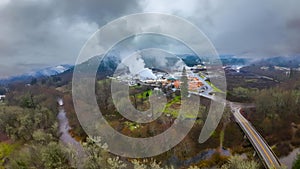 Picturesque small town surrounded by misty clouds, fog, and lush evergreen forest