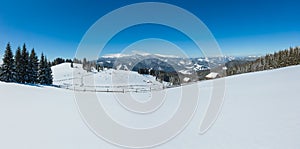 Picturesque snowy winter Skupova mountain slope and lone farmhouse on plateau farmstead, Carpathian, Ukraine, Verkhovyna district