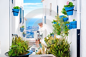 Picturesque street of Mijas with flower pots in facades photo