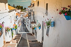 Picturesque street of Mijas with flower pots in facades. Andalusian white village. Costa del Sol. Southern Spain