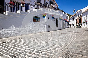 Picturesque street of Mijas with flower pots in facades. Andalusian white village. Costa del Sol. Southern Spain