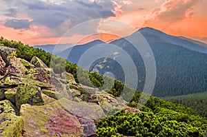 Picturesque sunset in the mountains. View from the hillside with a pile of scattered large stones. Gorgany mountain range,