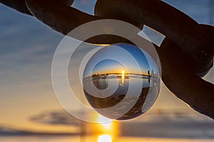 Picturesque sunset reflected in a glossy glass ball.