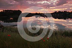 Picturesque sunset scenery at lake seeon, lake shore with red po