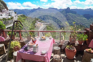 Picturesque terrace viewpoint in Artenara cave houses. Patio or tarraze with garden above mountains