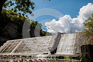 Picturesque landscape of a dam on a river, a flying seagull, rocks and a forest