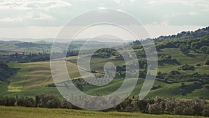 Picturesque Tuscany rural landscape with green hills, cypress trees, vineyards