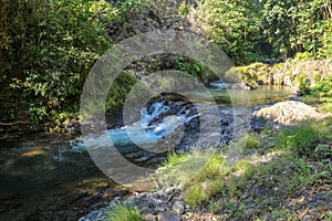 Picturesque valley in mountains and calm river. Boulders in the riverbed and rocks along the valley.