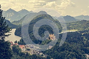 Picturesque view of Bavarian castle with lake surrounded with forest.