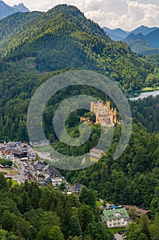 Picturesque view of Bavarian castle with lake surrounded with forest.