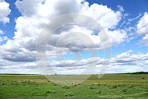 Picturesque view of beautiful fluffy clouds in light blue sky above field