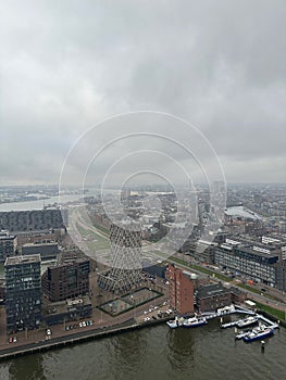 Picturesque view of city with modern buildings and harbor on cloudy day