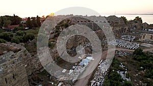 Picturesque view from drone of ruins of ancient Roman amphitheater at archaeological site in Side on background of blue