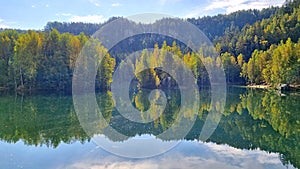 Reflection of autumn trees in a mountain lake of the rocky town of Adrspach, Czech Republic