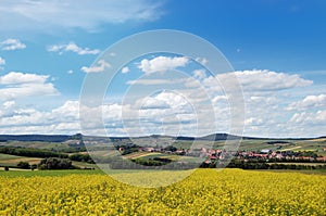 Picturesque view of hilly countryside area with rapeseed field