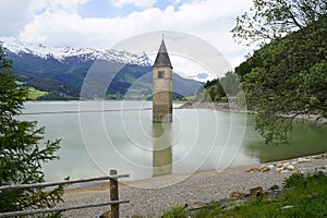 scenic view of lake Resia and sunken church steeple of Lago di Resia in Curon region (Vinschgau, South Tyrol, Italy) photo