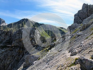 A picturesque view of the mountain stony slopes of the rocks against the background of the blue sky. Natural tourist landscape