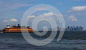 Picturesque view of New York, with yellow Staten Island Ferry and blue sky.