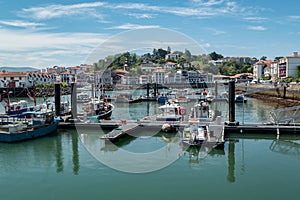 Port of Saint Jean de Luz with some boats anchored with part of the city in the background photo