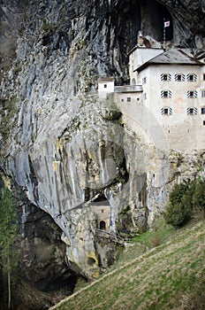 Picturesque view of the Predjama Castle situated in the middle of a towering cliff in Slovenia