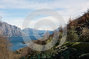 A picturesque view of the sea bay under a forest-covered mountain. Mountain ranges can be seen in the distance