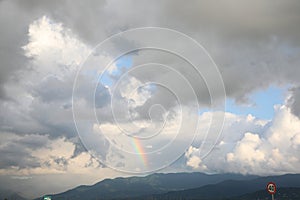 Picturesque view of sky with heavy rainy clouds and rainbow