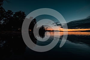 Picturesque view of a sunrise over a scenic lake with clouds reflecting on the water