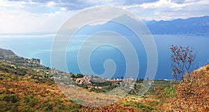 Picturesque view to garda lake and shrubbery in autumnal colors, italy