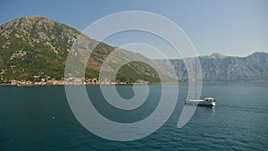 A picturesque view of the waters of the Bay of Kotor and the high mountains rising in the background. One of the most popular