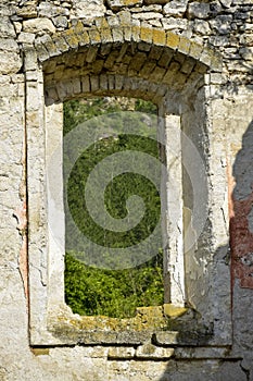 Picturesque view through window of old ruined building. Ruins of ancient synagogue in Rashkov, Moldova. Old stonework.